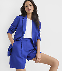 A woman in a blue blazer and shorts stands against a plain white background. carousel Product Image 2
