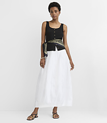 A woman in a black top and white skirt stands against a plain white background. carousel Product Image 1