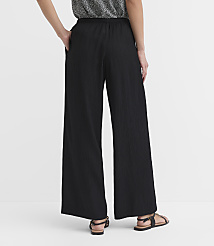 A person wearing black wide-leg pants and sandals stands against a plain white background. carousel Product Image 3