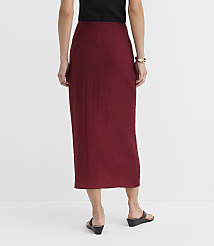 A woman in a maroon textured skirt and black top stands against a plain white background. carousel Product Image 3