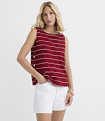 A woman in a red and white striped sleeveless top and white denim shorts stands against a plain white background. carousel Product Image 1