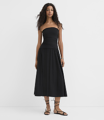 A woman in a black strapless dress and sandals stands against a plain white background. carousel Product Image 1