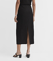 A person wearing a black ribbed midi skirt with a slit and black block heels stands against a plain white background. carousel Product Image 3