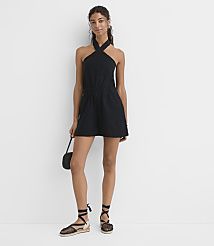 A woman in a black halter romper and espadrille sandals stands against a plain white background, holding a small black purse. carousel Product Image 2