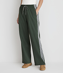 A person stands in dark green athletic pants with white stripes down the sides, wearing brown loafers against a plain white background. carousel Product Image 2