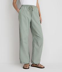 A person stands in light green pants with a drawstring waist and sandals, against a plain white background. carousel Product Image 2