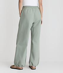 A person wearing loose-fitting, light green pants with elastic cuffs stands with their back to the camera against a plain white background. carousel Product Image 3