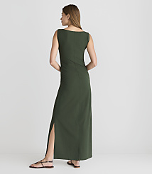 A woman in a long, dark green dress with a thigh-high slit stands on a white floor against a plain white background. carousel Product Image 3