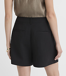 A person wearing black shorts and a taupe top stands against a plain white background. carousel Product Image 2