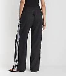A person wearing black wide-leg pants with white stripes stands against a plain white background. carousel Product Image 3
