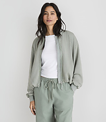 A woman in a light green bomber jacket and matching pants stands against a plain white background. carousel Product Image 1