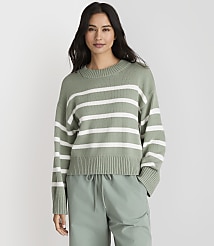 A woman in a green and white striped sweater and light green pants stands against a plain gray background. carousel Product Image 1