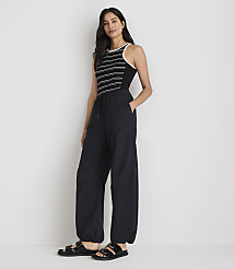 A woman in a striped tank top and baggy pants stands against a plain white background. carousel Product Image 1