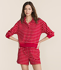 A woman in a red and white striped polo shirt and matching shorts stands against a plain, light-colored background. carousel Product Image 1