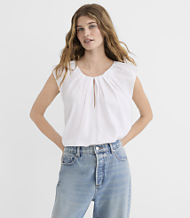 A woman in a white top and blue jeans stands against a plain white background. carousel Product Image 2