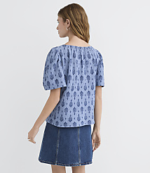 A woman in a blue patterned top and denim skirt stands against a plain white background. carousel Product Image 3