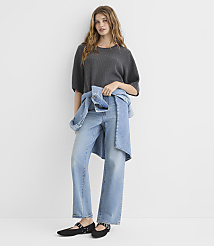 A woman in a gray sweater and light-wash jeans stands against a plain white background. carousel Product Image 2