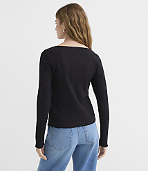 A woman in a black ribbed top and blue jeans stands against a plain white background. carousel Product Image 3