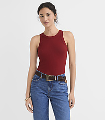 A woman in a maroon ribbed tank top and blue jeans stands against a plain white background. carousel Product Image 1