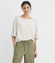 A woman in a light-colored oversized shirt and green striped pants stands against a plain white background. carousel Product Image 1