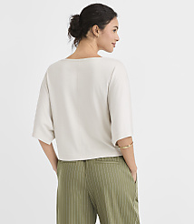A woman in a light-colored top and green pinstripe pants stands with her back to the viewer against a plain white background. carousel Product Image 3