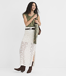 A smiling woman in a white lace skirt and green top stands against a plain white background. carousel Product Image 1