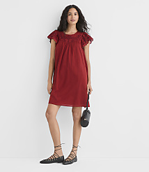 A woman in a red embroidered dress and black lace-up flats stands against a plain white background, holding a black purse. carousel Product Image 1