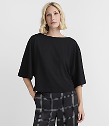 A woman in a black boatneck top and plaid pants stands against a plain white background. carousel Product Image 1