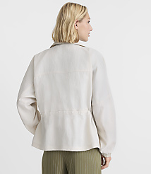 A woman in a light-colored jacket stands against a plain, light background. carousel Product Image 3