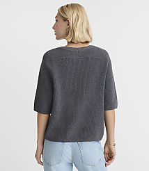A woman in a gray sweater and light blue jeans stands against a plain white background. carousel Product Image 3