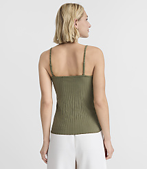 A woman in a green ribbed tank top and white pants stands against a plain white background. carousel Product Image 3