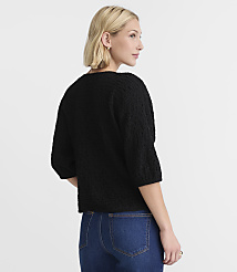 A woman in a black sweater and blue jeans stands against a plain white background. carousel Product Image 3
