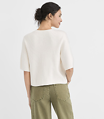A woman in a cream-colored sweater and olive green pants stands against a plain white background. carousel Product Image 3