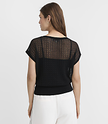 A woman in a black sheer top and white pants stands against a plain white background. carousel Product Image 3
