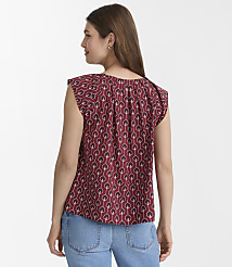 A woman in a patterned maroon blouse and blue jeans stands against a plain white background. carousel Product Image 3