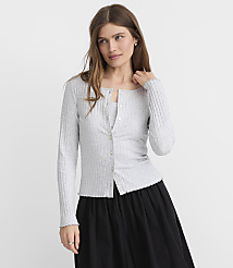 A woman in a light gray ribbed cardigan and black skirt stands against a plain gray background. carousel Product Image 1