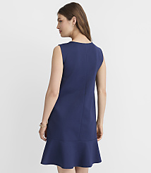 A woman in a navy blue sleeveless dress with a ruffled hem stands against a plain white background. carousel Product Image 3