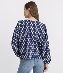 A woman in a blue and white patterned blouse and jeans stands against a plain white background. carousel Product Image 3