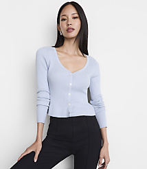 A woman in a light blue cardigan and black pants stands against a plain white background. carousel Product Image 2