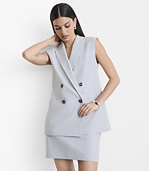 A woman in a light gray sleeveless blazer and matching skirt stands against a plain white background. carousel Product Image 2
