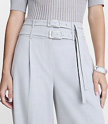 A person in a grey ribbed top and light grey pleated pants with a double buckle belt stands against a plain white background. carousel Product Image 4