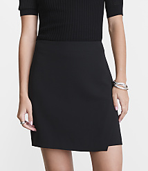 A woman in a black skirt and ribbed top stands against a plain white background, accessorized with rings and a bracelet. carousel Product Image 2