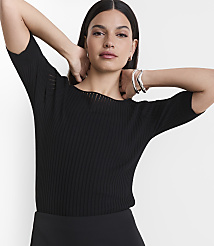 A woman in a black ribbed top and silver bracelets poses with her hands behind her head against a plain white background. carousel Product Image 2