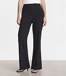 A person stands in black flared pants and a white top against a plain white background. carousel Product Image 2