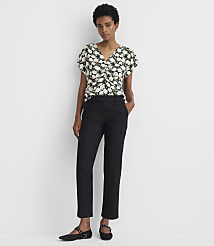 A woman in a floral top and black pants stands against a plain white background. carousel Product Image 1