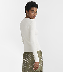 A woman in a white ribbed sweater and a green polka-dot skirt stands against a plain white background. carousel Product Image 3