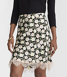 A black floral print mini skirt with a lace hem is modeled against a plain background. carousel Product Image 2