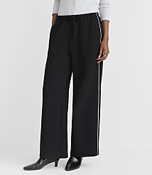 A person stands in black wide-leg pants with white side stripes and black heeled boots against a plain white background. carousel Product Image 2