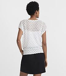 A woman in a white polka-dot blouse and black skirt stands against a plain white background. carousel Product Image 3
