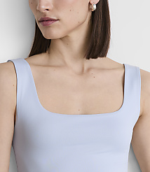 A woman with a square neckline top and a pearl earring is shown against a plain white background. carousel Product Image 4